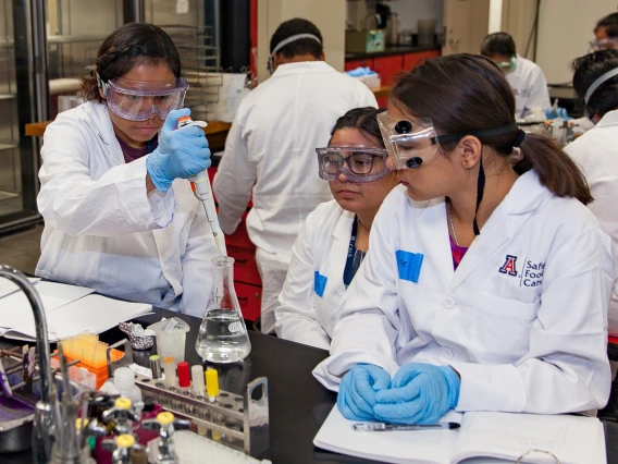 two female students with female instructor in lab