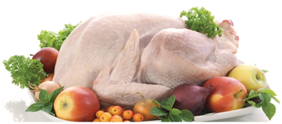 uncooked turkey surrounded by fruit