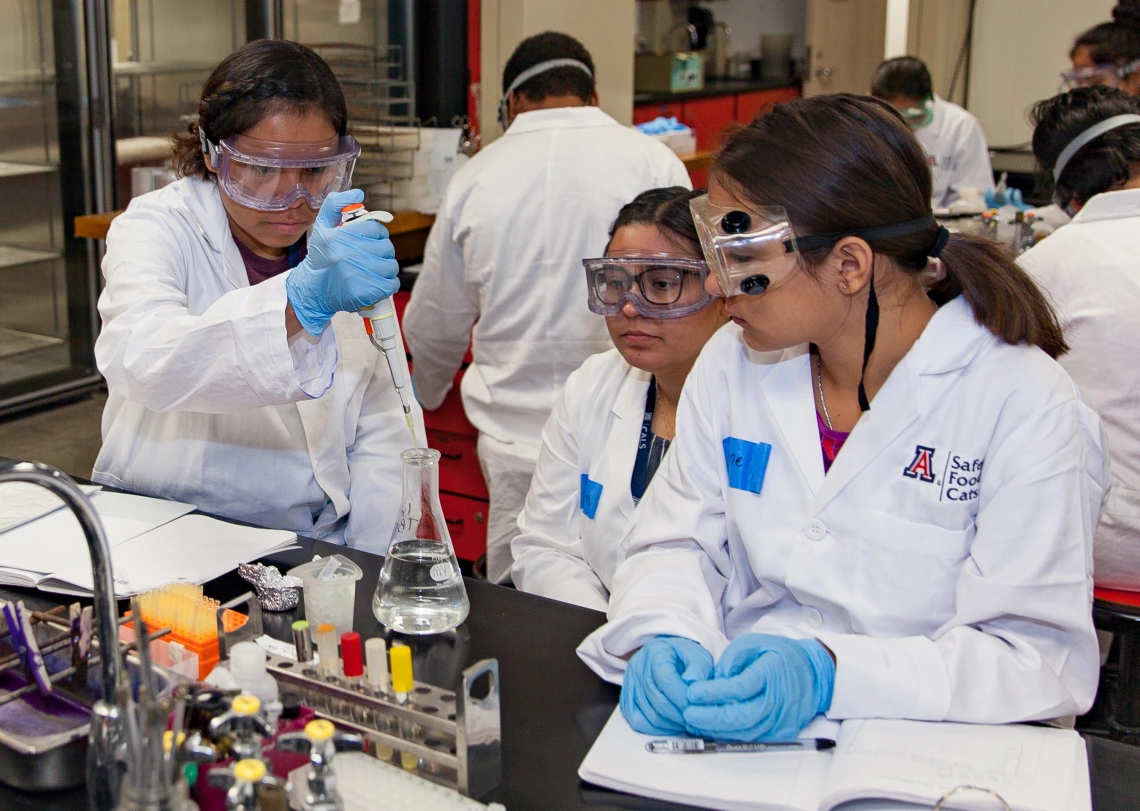 two female students with female instructor in lab