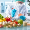 main in laboratory with fruits and vegetables holding petri dish