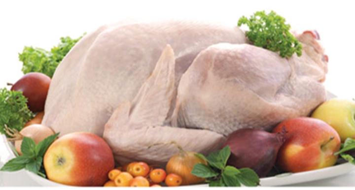 uncooked turkey surrounded by fruit